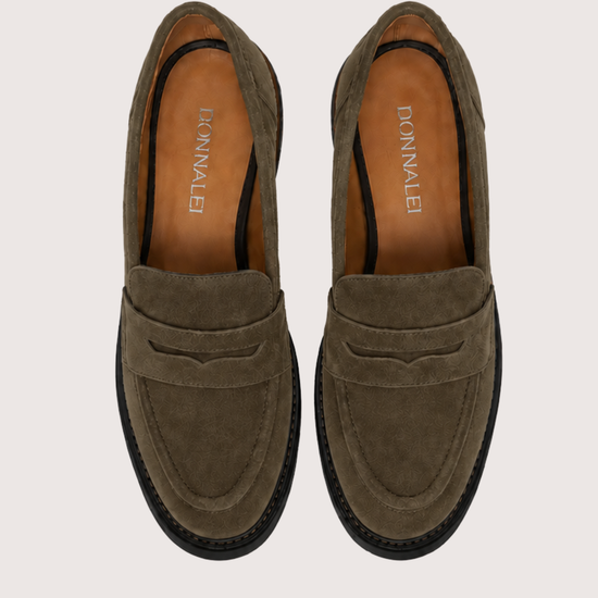 A pair of khaki suede penny loafers with black soles, shown from a top-down view on a light beige background. The brand name 'DONNALEI' is printed on the tan insoles.