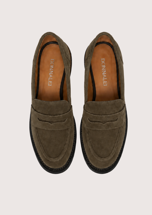 A pair of khaki suede penny loafers with black soles, shown from a top-down view on a light beige background. The brand name 'DONNALEI' is printed on the tan insoles.
