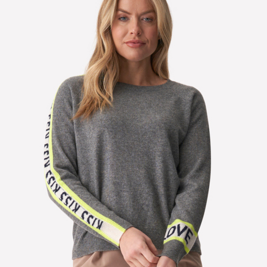 Grey jumper with white writing down the sleeves that says love and kisses