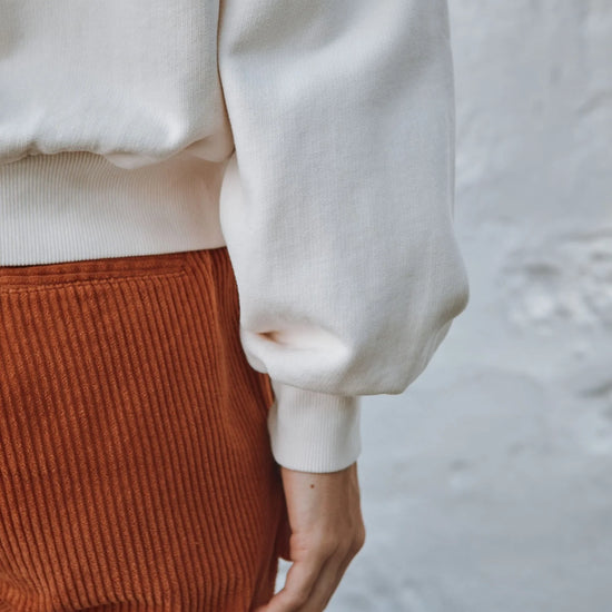 round frill neck cream sweatshirt with button shoulder detailing close up