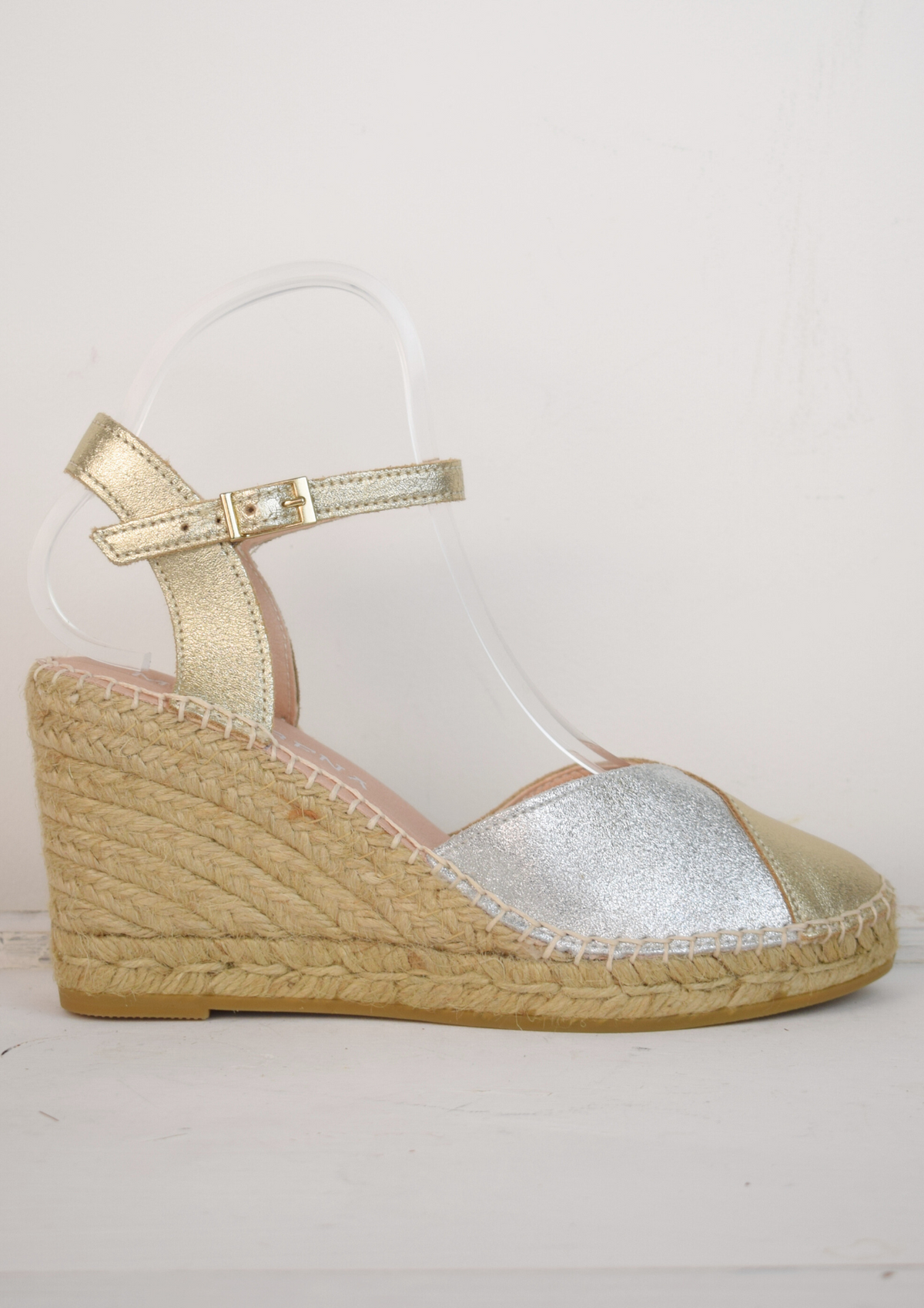 A raffia wedge sandal with a 2 tone top. Made up of silver and gold.
