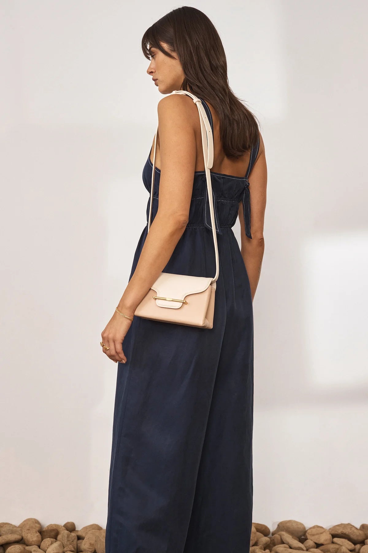 Navy wide leg jumpsuit with deep V neckline and thick tie straps at the back with white contrast stitching