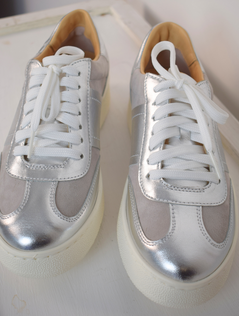 grey trainers with silver detail and white laces 