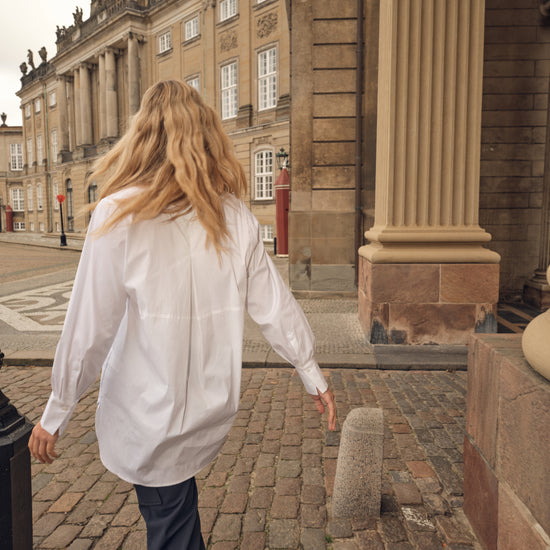white shirt with concealed placket, curved hem and classic collar model shot rear view