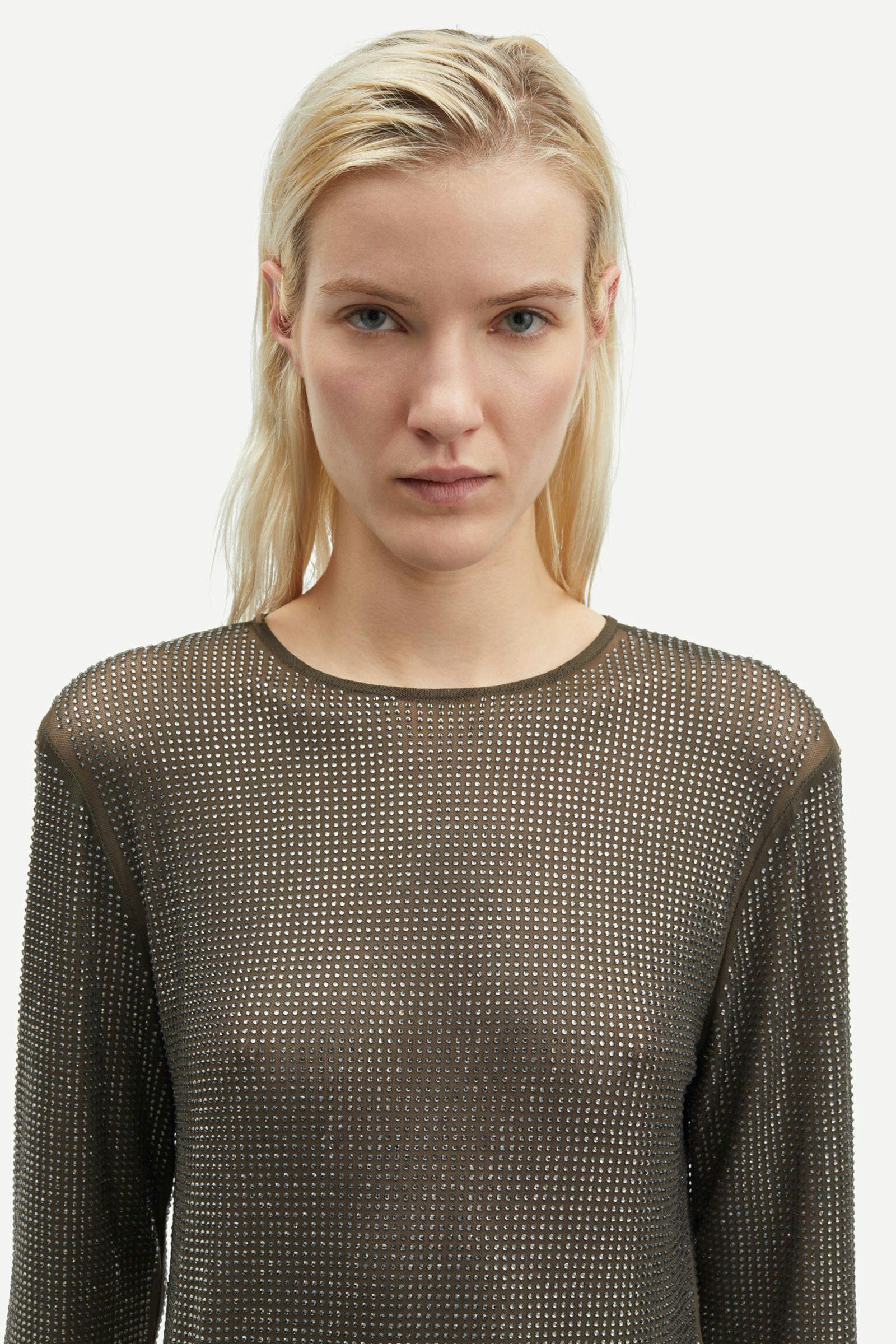 dark grey mesh top covered in rhinestones with round neck and long sleeves  close up