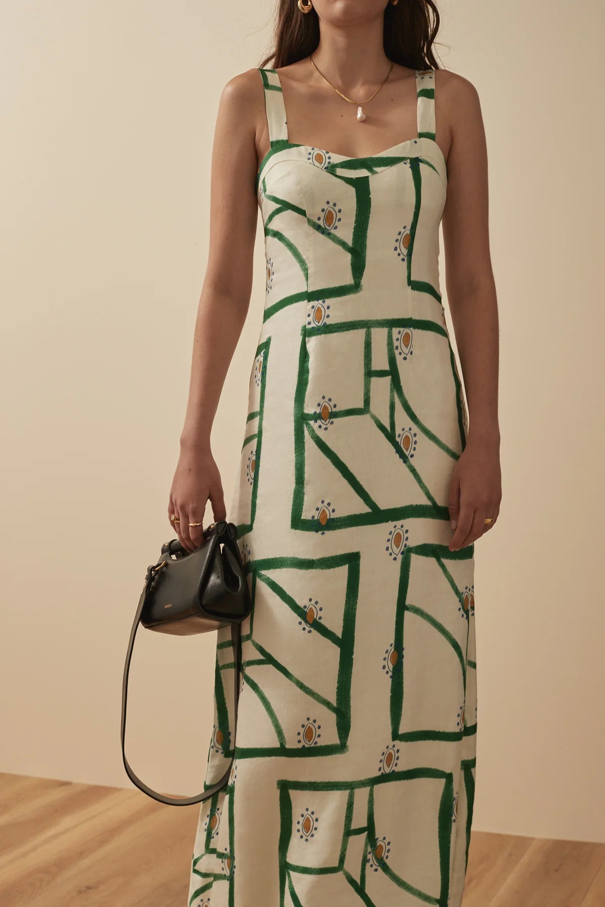 White sleeveless summer dress with a green print