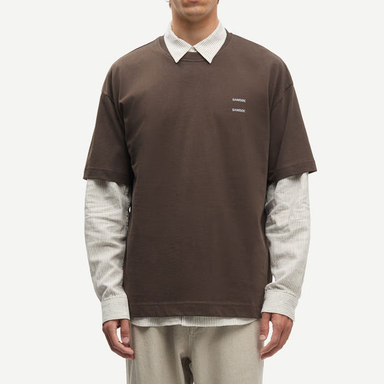 Man wearing a Brown Samsoe Samsoe T shirt over a shirt
