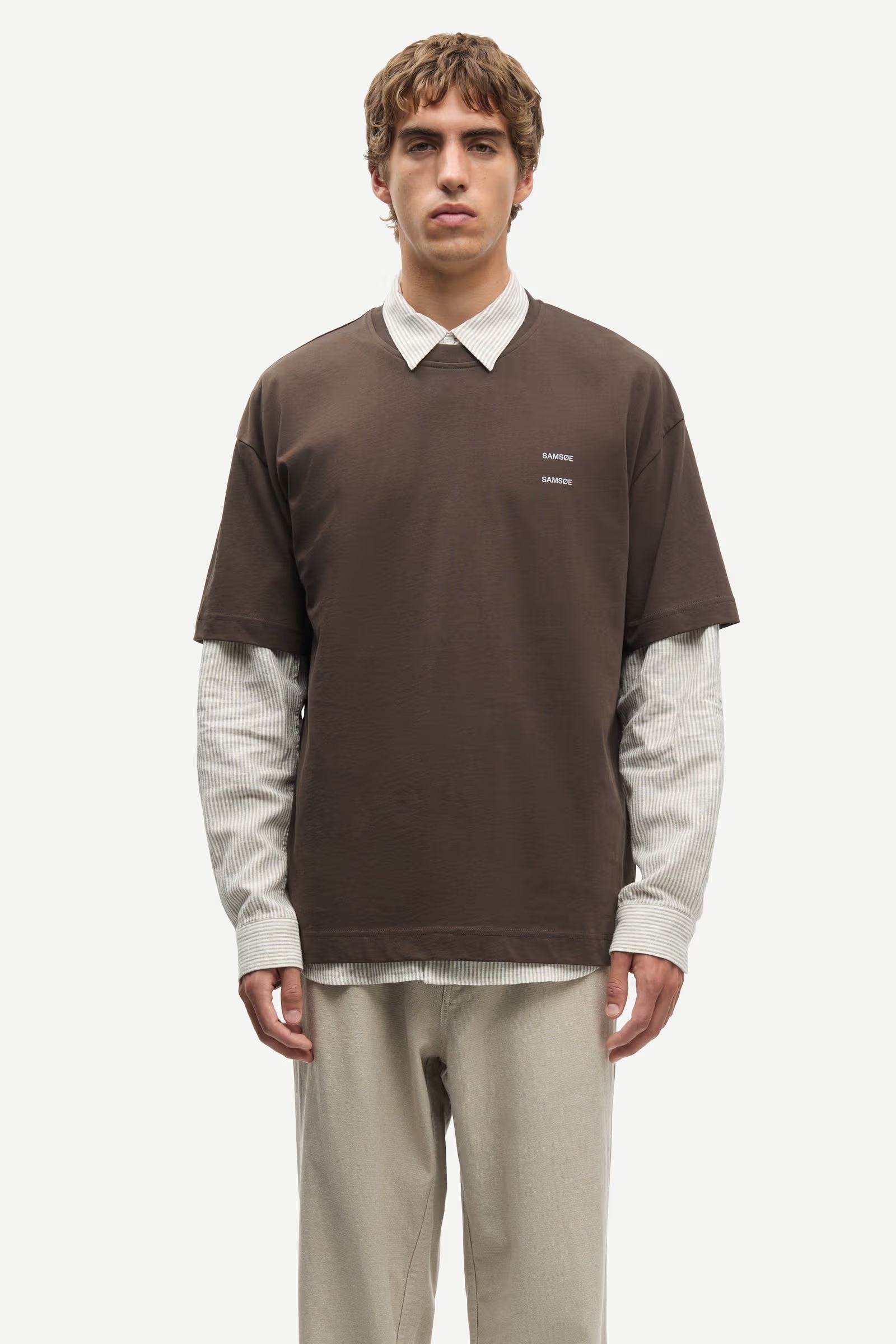 Man wearing a Brown Samsoe Samsoe T shirt over a shirt