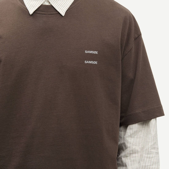 Man wearing a Brown Samsoe Samsoe T shirt over a shirt close up