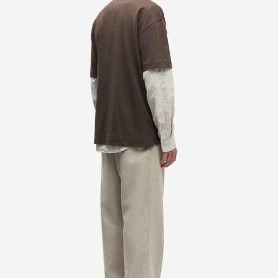 Man wearing a Brown Samsoe Samsoe T shirt over a shirt rear view