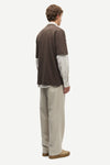 Man wearing a Brown Samsoe Samsoe T shirt over a shirt rear view