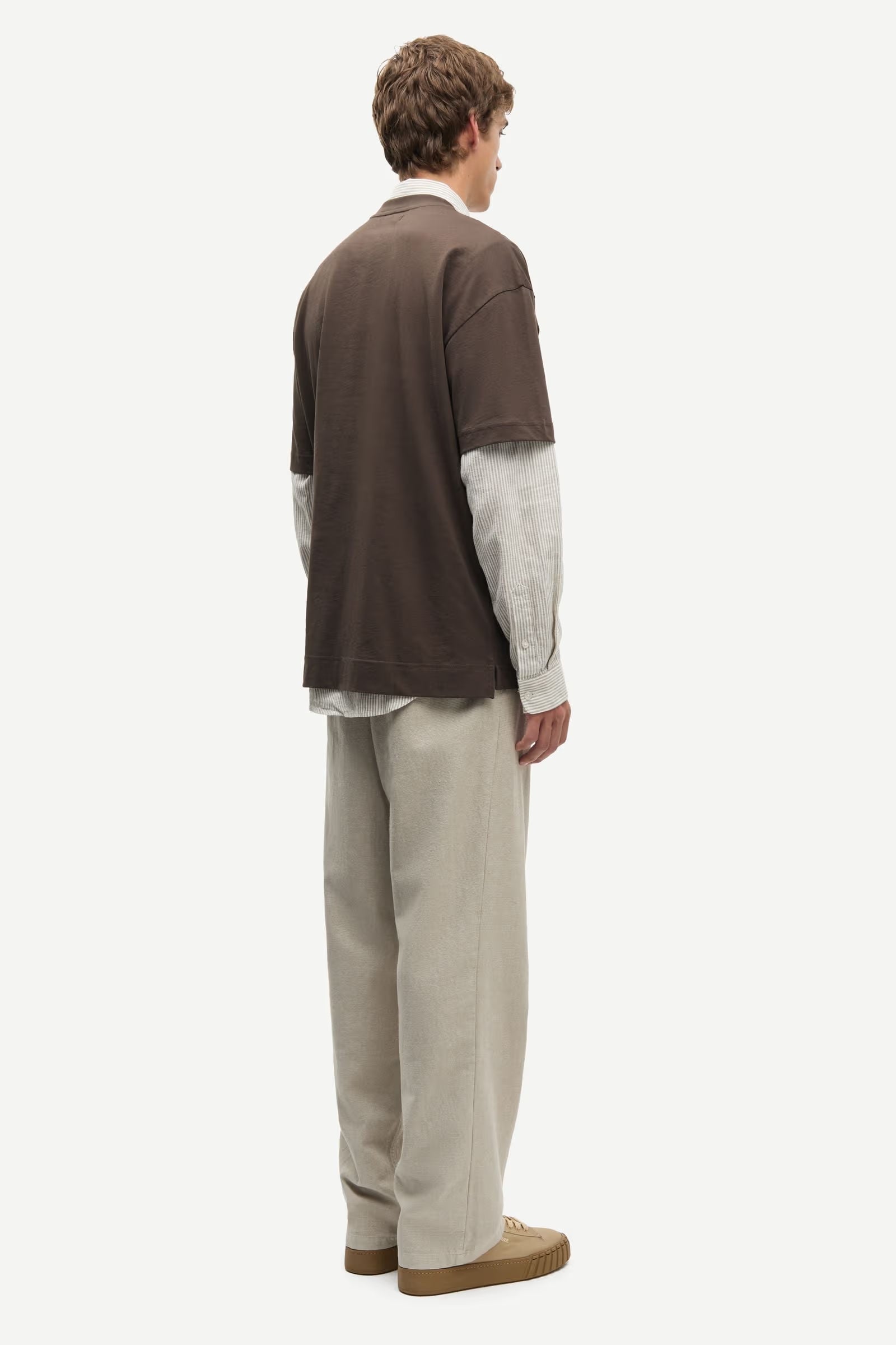 Man wearing a Brown Samsoe Samsoe T shirt over a shirt rear view
