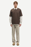 Man wearing a Brown Samsoe Samsoe T shirt over a shirt front view