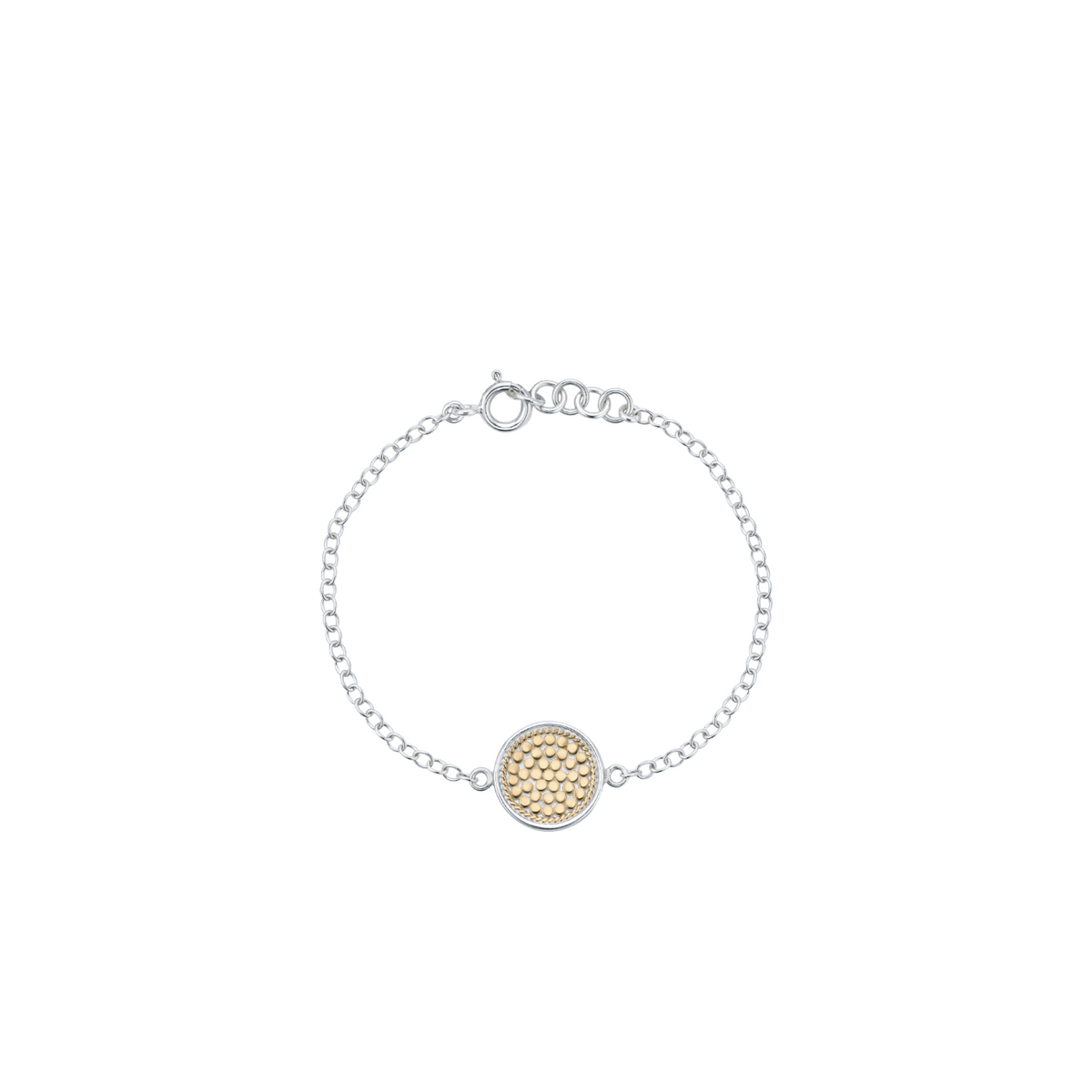 A delicate silver chain bracelet with a central round gold-tone textured disc charm, displayed on a clean white background.