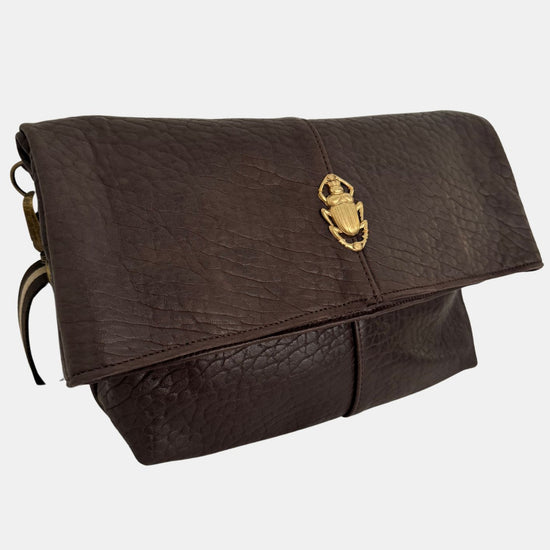 brown lamb leather fold over bag with adjustable strap and gold scarab detail side view 