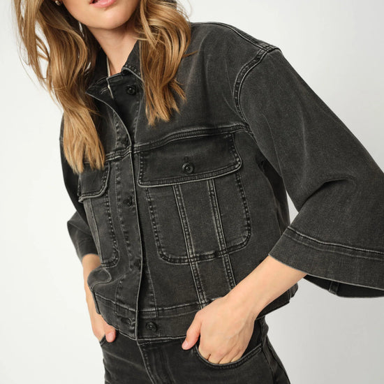 Person wearing a grey denim jacket on a plain background from Mos Mosh