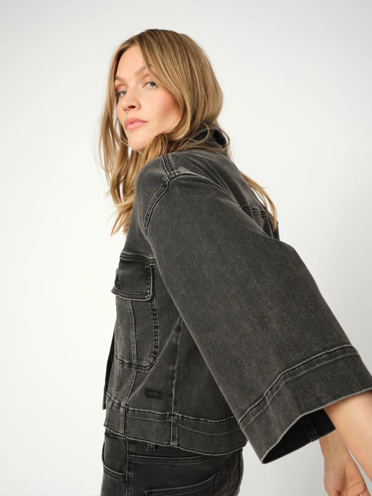 Woman wearing a grey denim jacket on a white background from Mos Mosh