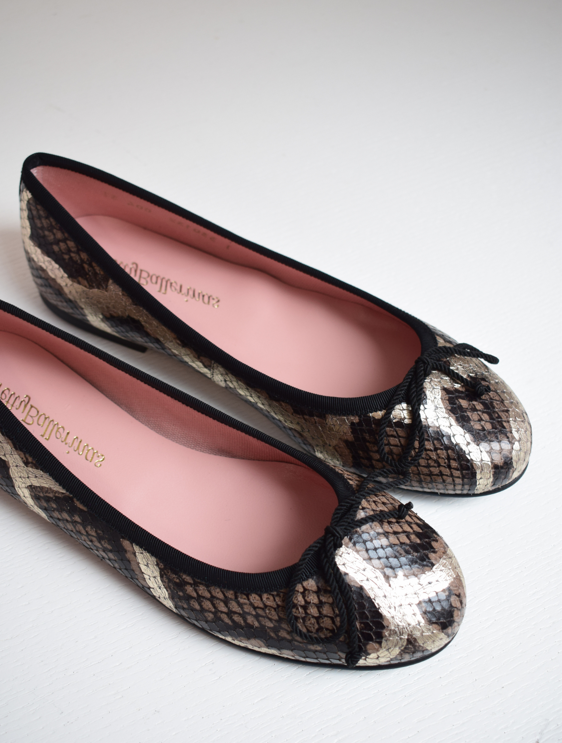 Mock snake leather ballet pumps with black bow on toe with gold shimmer detail