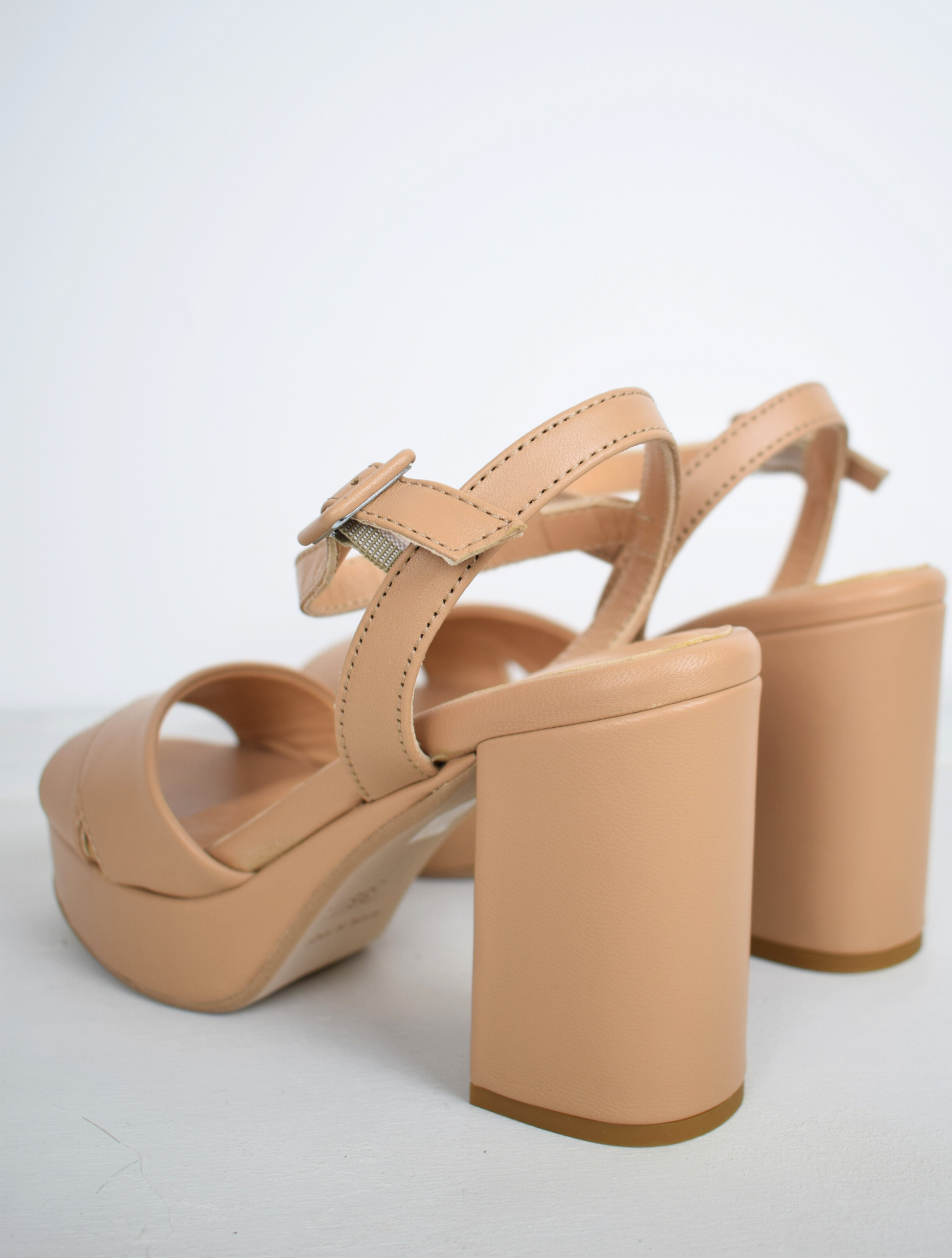 Nude leather platform sandal with cross straps and ankle strap with buckle fastening