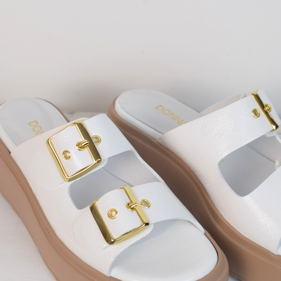 White platform slider with double strap gold metallic buckles and taupe coloured rubber platform sole