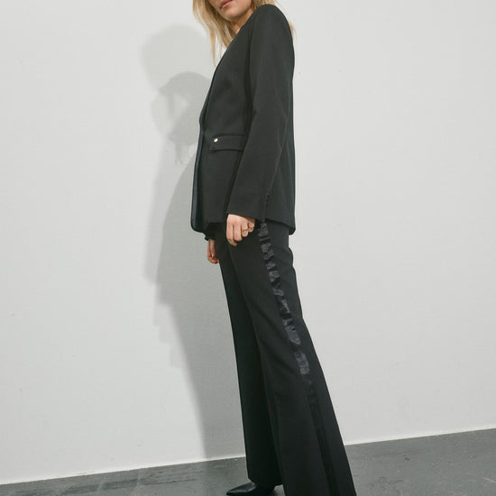 black single satin lapel blazer with single covered buttons and 2 welt flat pockets side view 