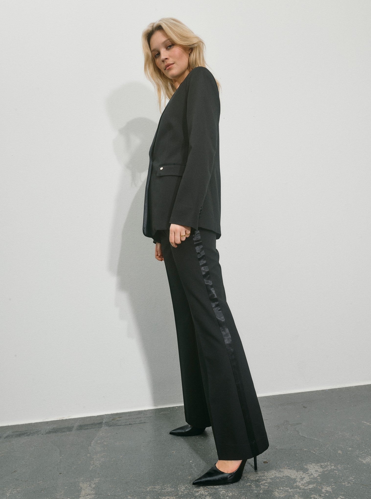 black single satin lapel blazer with single covered buttons and 2 welt flat pockets side view 