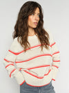 model wearing cream jumper with orange stripes on it 