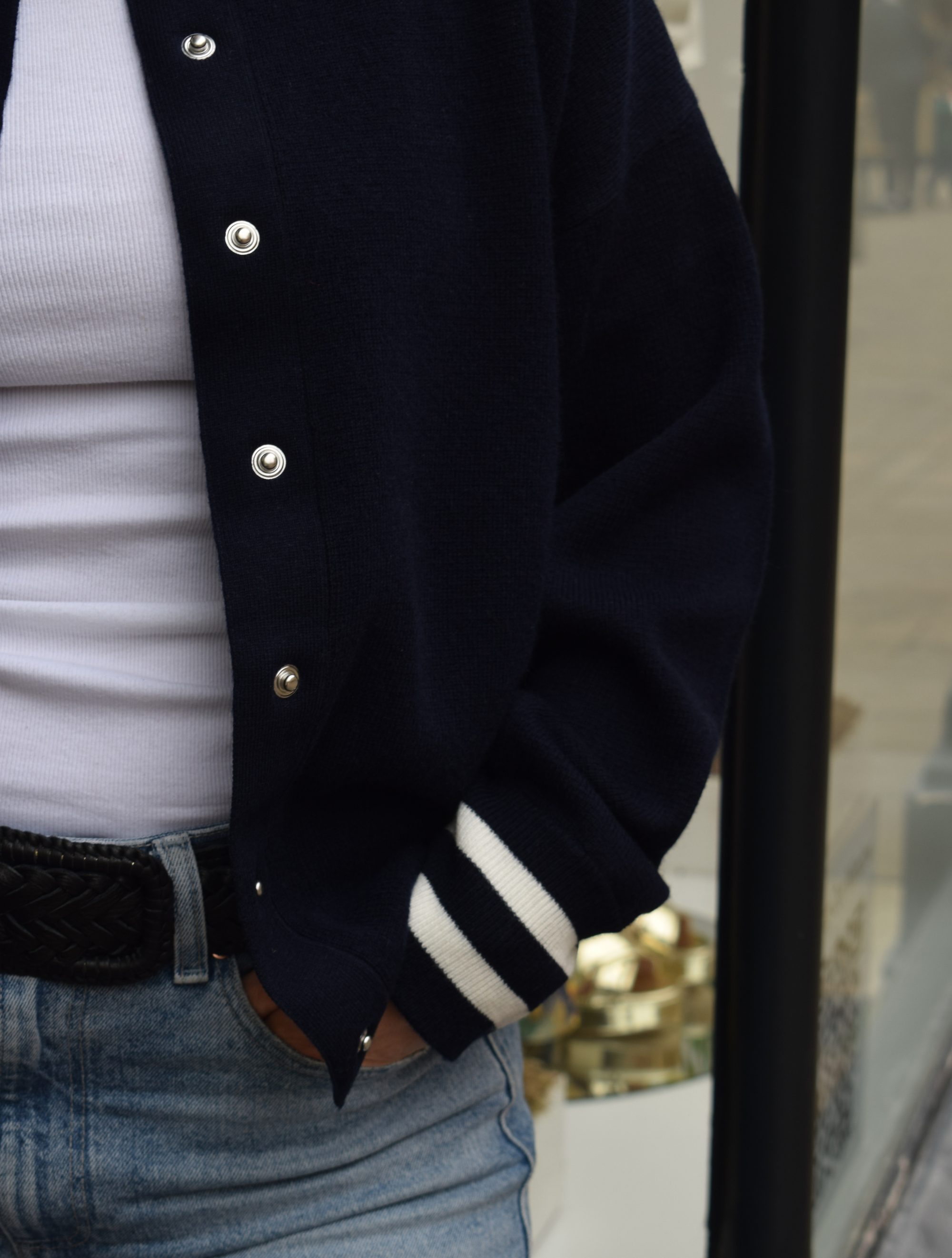 Navy bomber jacket with white stripes around the neck and sleeve cuffs