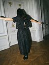 Model shown spinning around wearing a matching black sequins skirt and top set.
