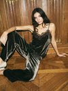 Model wearing a brown velvet camisole and trouser set sat on the floor on a wooden background