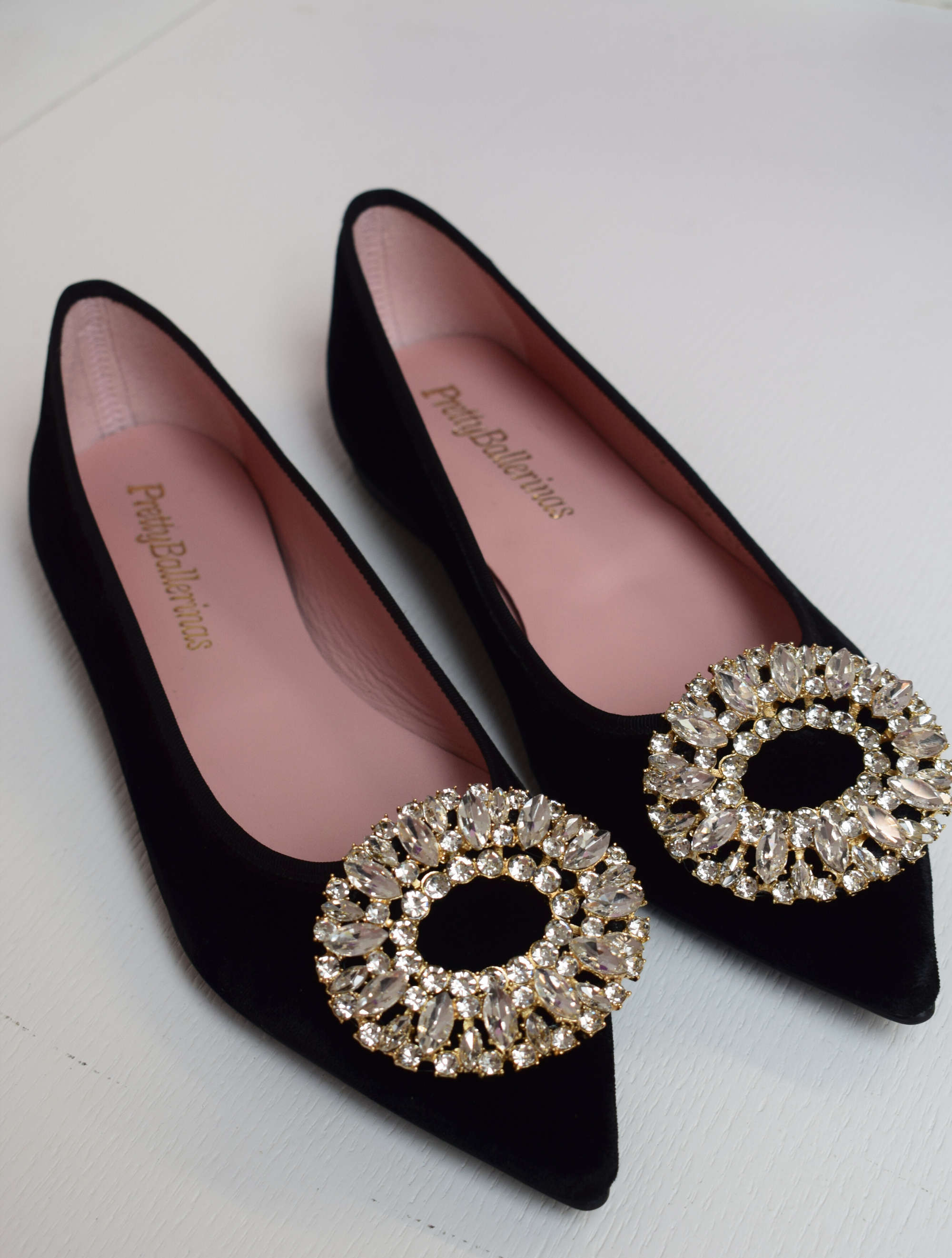 Black velvet pointed toe ballet pumps with gold and diamante brooch on toe