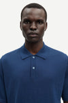 Man wearing a blue polo shirt against a white background