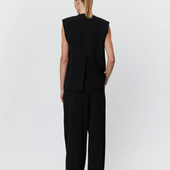 Black asymmetric waistcoat with large button on right shoulder and centre rear vent