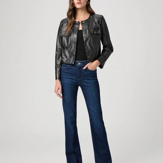 Woman wearing a black leather jacket and blue jeans on a white background