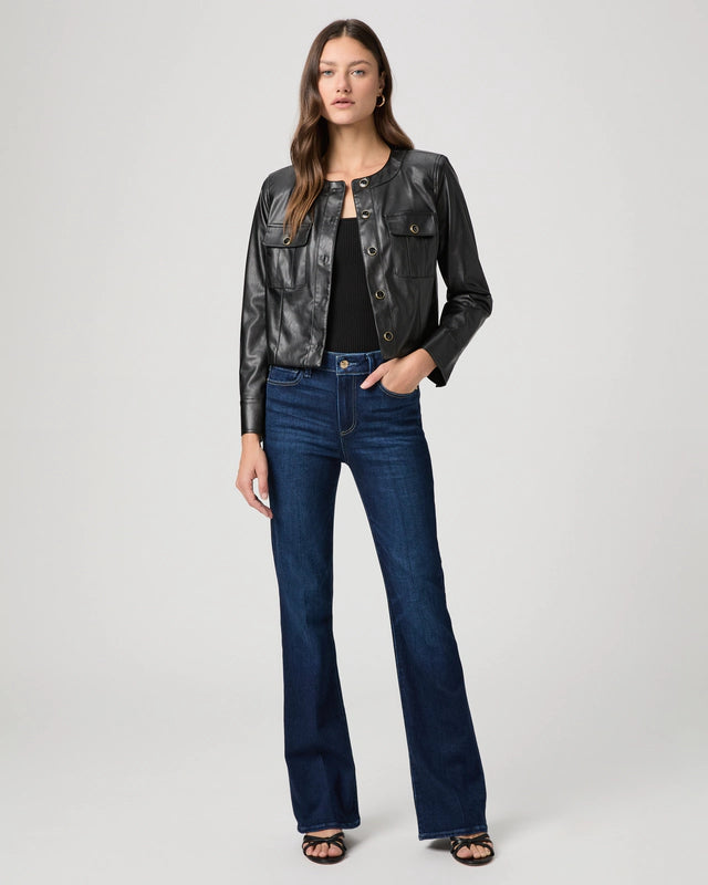 Woman wearing a black leather jacket and blue jeans on a white background