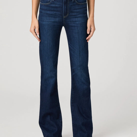 Person wearing blue flared jeans on a white background