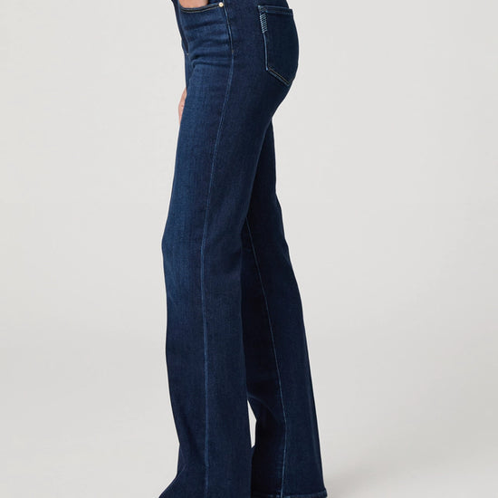 Person wearing dark blue jeans on a white background