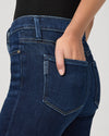 Close-up of blue jeans with a hand in the pocket on a light gray background