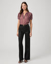 Black waxed look wide leg jeans worn with pink short sleeve blouse