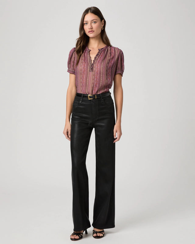 Black waxed look wide leg jeans worn with pink short sleeve blouse