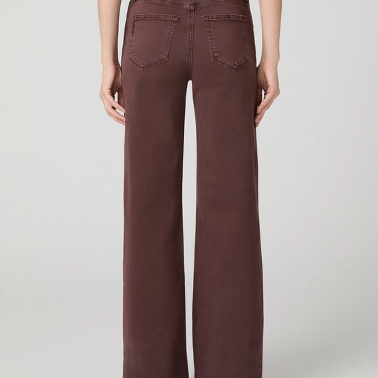 model facing away from the camera with dark berry coloured jeans on on a white background