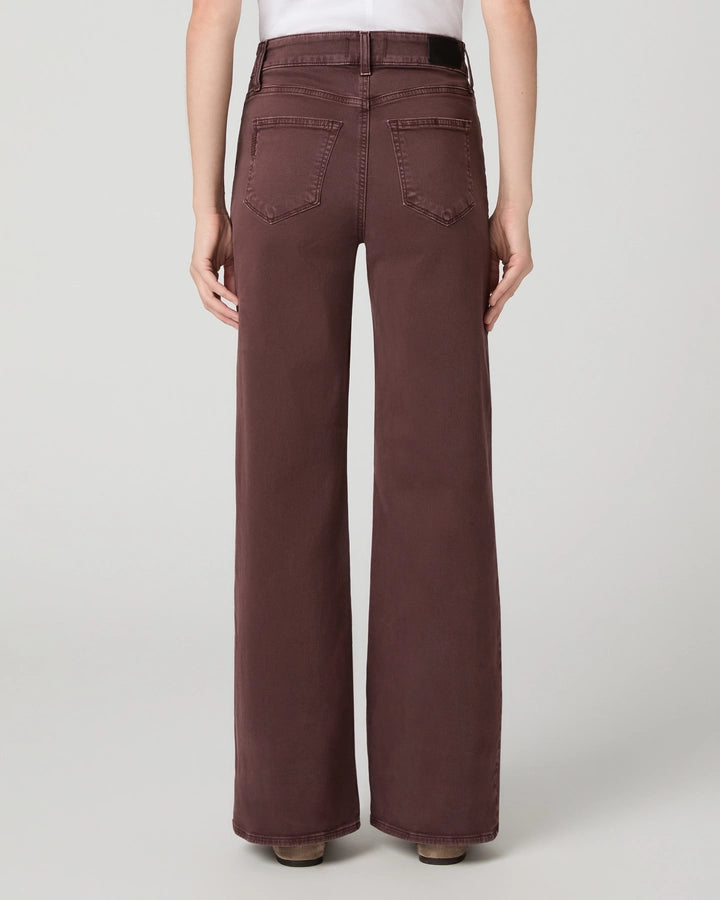 model facing away from the camera with dark berry coloured jeans on on a white background