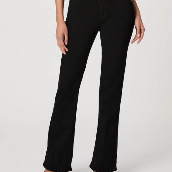 Black bootleg jeans worn by a person on a white background