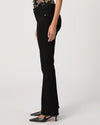 Black flared jeans worn by a person on a white background