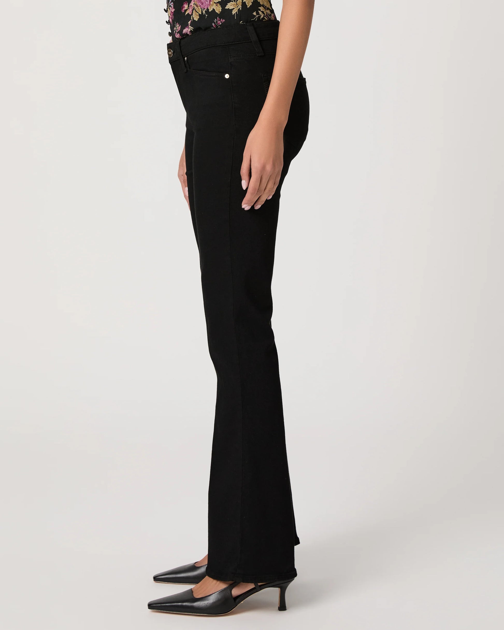 Black flared jeans worn by a person on a white background