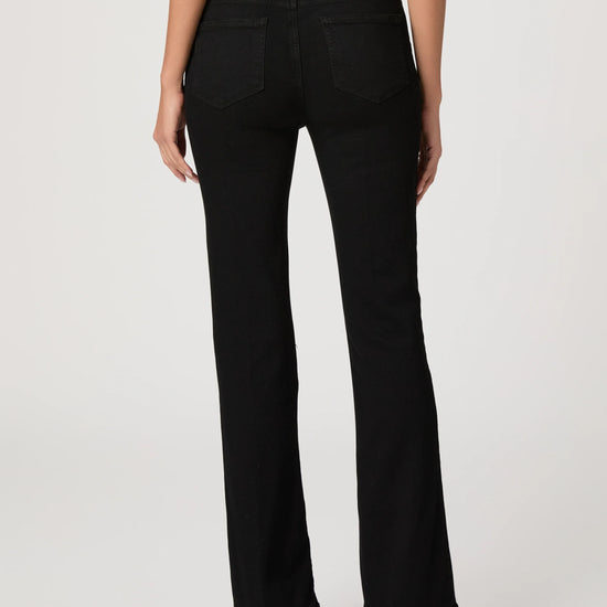 Black flared jeans worn by a person on a white background