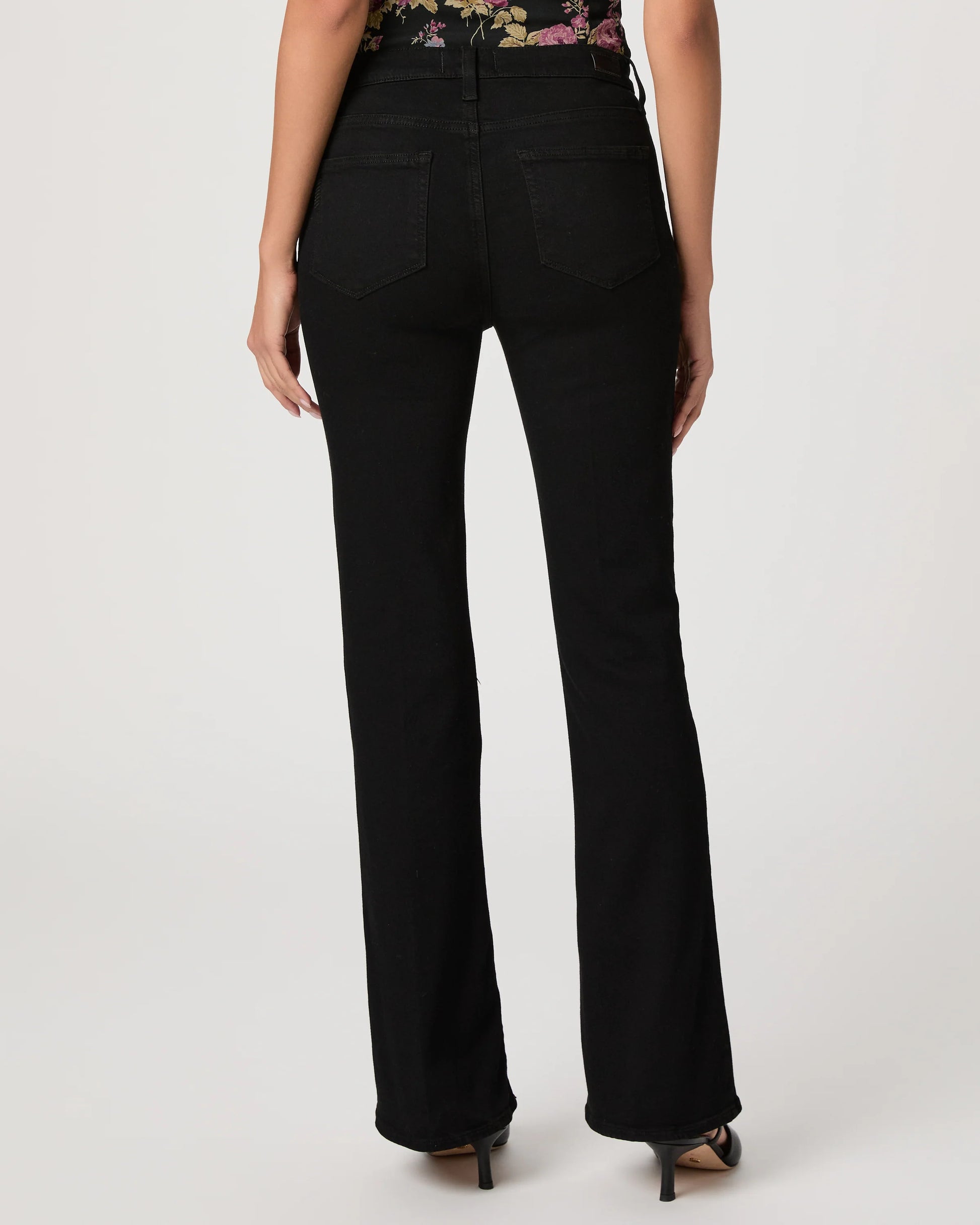 Black flared jeans worn by a person on a white background
