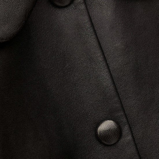 Close-up of a black leather coat with buttons
