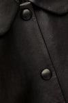 Close-up of a black leather coat with buttons