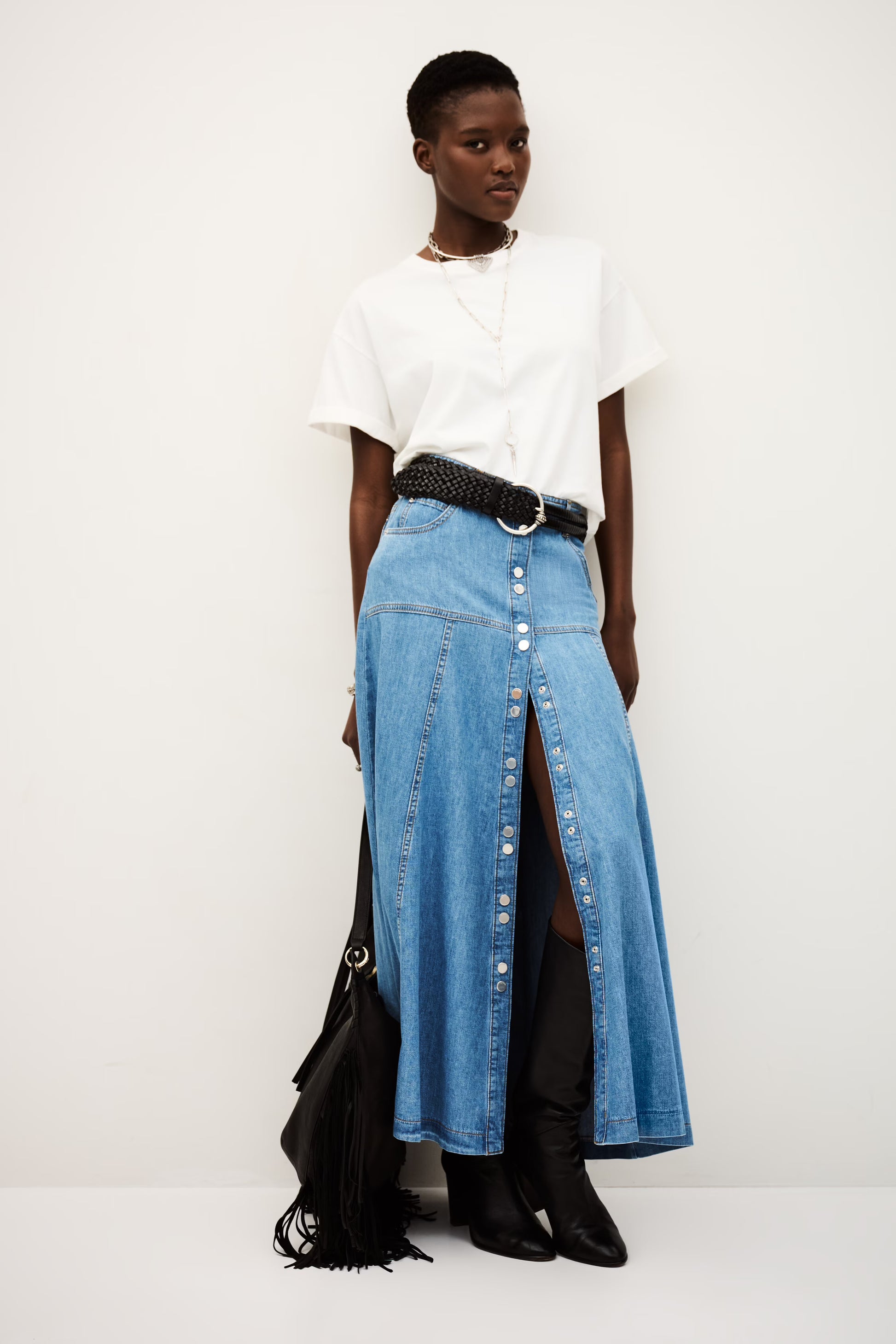 Person wearing a white top, blue denim skirt, and black shoes on a white background from ba&sh